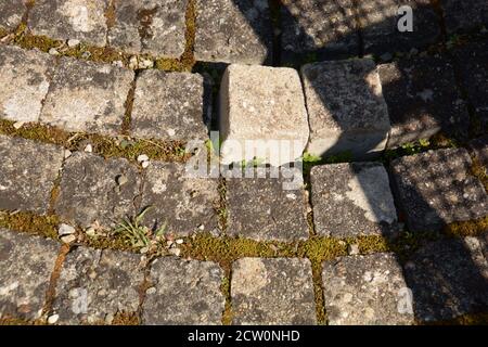 part of dirty and loose cobblestone walkway with light and shadow effects Stock Photo