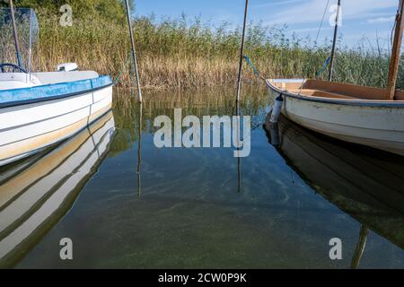 Reflection in green water between two small boats in a lake. Picture from Ringsjon, Scania county, Sweden Stock Photo