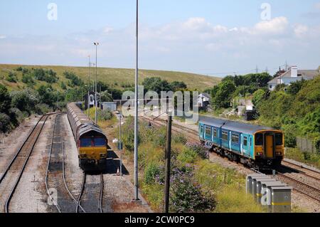 '150251' on a Bridgend service passes '66050 EWS Energy' at Aberthaw. Stock Photo