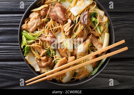 Glass Noodles with pork belly, mushrooms and napa cabbage close-up in a plate on the table. horizontal top view from above Stock Photo
