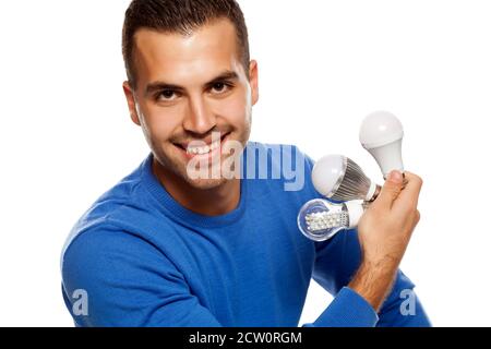 portrait of happy young man, holding three different LED bulbs on white background Stock Photo