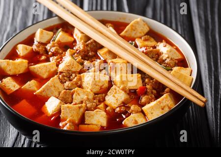 Mapo Tofu is a fiery Sichuan pork and tofu stir-fry with the hallmark mala balance of tongue tingling and spicy closeup in the plate on the table. Hor Stock Photo