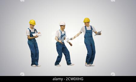 Three young construction workers in hardhats passing on document Stock Photo