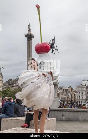 London UK 26 September 2020 A demonstrator at todays rally in Trafalgar Square performing with feathers in front of the 4th plinth, The End, art work by artist Heather Phillipson.Paul Quezada-Neiman/Alamy Live News Stock Photo