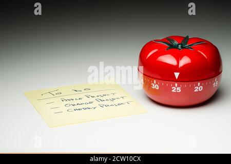 Tomato-shaped kitchen timer set at 25 minutes to fight procrastination in studying and working. Stock Photo