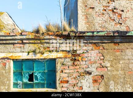 Grunge damaged broken windows in brick ruined building wall Stock Photo