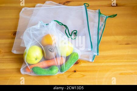 Zero waste principle. Plastic free recycled textile bag for fruit or vegetables on a wooden surface. Stock Photo