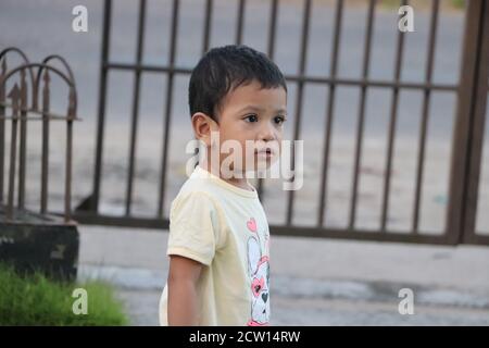 Cute little baby boy standing outside and looking with worries in the face Stock Photo