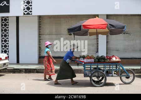 Yangon, Myanmar. 26th Sep, 2020. A street vendor wearing a mask pushes a cart of fruits in Yangon, Myanmar, Sept. 26, 2020. The number of COVID-19 infection cases in Myanmar reached 9,991 on Saturday night, said a release from the Health and Sports Ministry. According to the release, Myanmar reported 880 new confirmed cases and 24 more deaths on Saturday night. Credit: U Aung/Xinhua/Alamy Live News Stock Photo