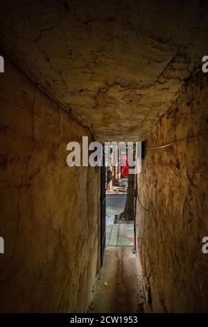 A dark narrow alley between two old row homes in Philadelphia, Pennsylvania USA Stock Photo