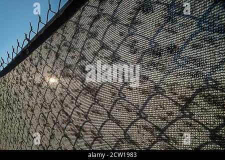 Dirty screen on chain link fence Stock Photo