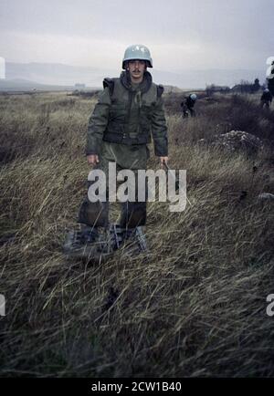 18th December 1995 During the war in Bosnia: French soldiers conducting mine clearance in heavy rain, around the runway at Mostar airport. Stock Photo