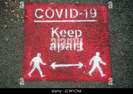 Isle of Wight, September 2020. Sandown. Painted sign on the pavement saying 'Covid 19 Keep apart'. Stock Photo