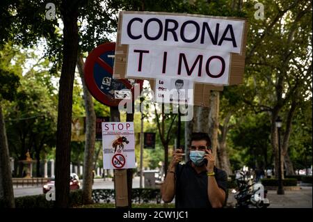 Madrid, Spain. 26th Sep, 2020. A man holds a placard reading 'corona scam' during a protest of coronavirus sceptics protesting against the use of face masks, vaccines and 5G. Credit: Marcos del Mazo/Alamy Live News Stock Photo