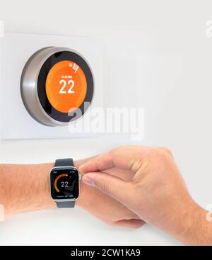 A person controlling a smart thermostat from a smart watch Stock Photo