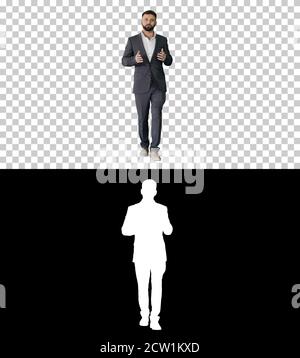 Bearded turk businessman walking and talking to camera, Alpha Ch Stock Photo
