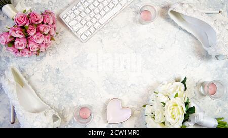 White aesthetic wedding bridal theme desktop workspace with high heel shoes, bouquets and accessories on stylish white textured background. Top view b Stock Photo