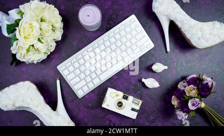 Wedding bridal theme desktop workspace with high heel shoes, bouquets and accessories on vintage purple textured background. Top view blog hero header Stock Photo