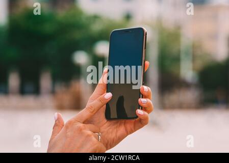 Woman's hands holding smartphone. Texting message or using mobile phone to check social media or unlocking device Stock Photo
