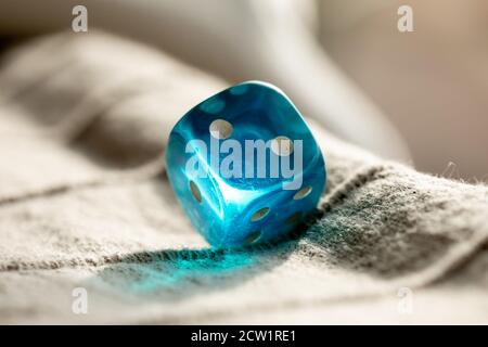 A Blue Dice refracting sunlight Stock Photo