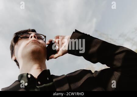 White young man holds a smartphone in his hand. Selective focus. Stock Photo
