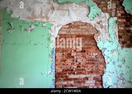 old abandoned brick wall coated with cracked plaster and paint, grunge background Stock Photo
