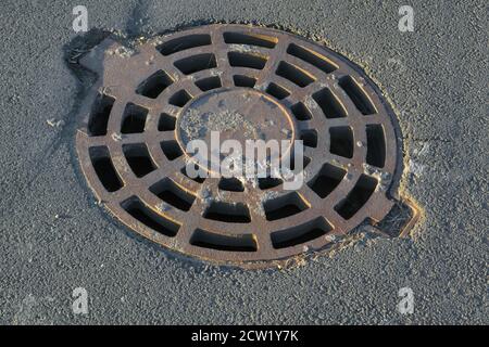 Cast-iron manhole cover storm sewer in the park Stock Photo