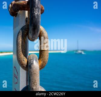 Anchor Chain Close Up with Blue Water Background in background Stock Photo
