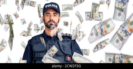 Young hispanic man wearing police uniform relaxed with serious expression on face. simple and natural looking at the camera. Stock Photo