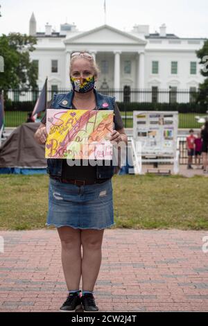 Female activist holds anti-racism sign in front of White House. Stock Photo