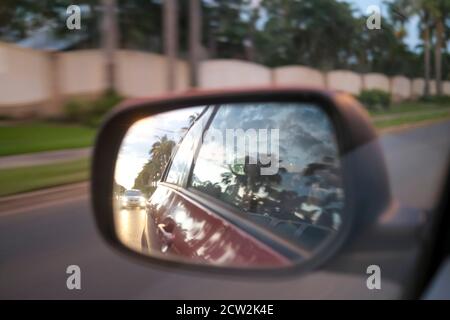 Side view mirror from a moving car with motion blur in the evening Stock Photo