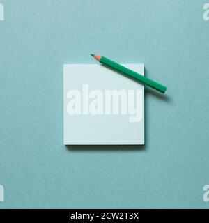 Green memo paper, sticky notes with colored pencil on green background. top view, copy space Stock Photo