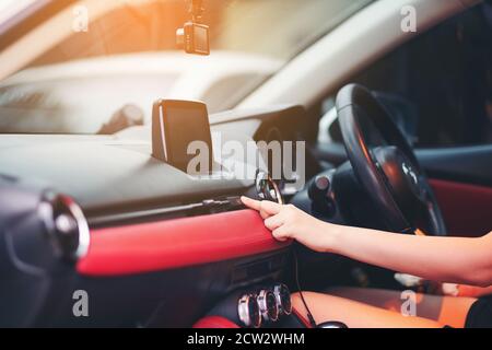 Woman finger pressing emergency button on car dashboard. Transportation Concept, The female hand presses the button to turn the alarm into the car Stock Photo