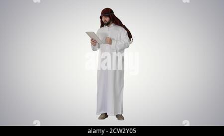 Arabic business man with tablet on gradient background. Stock Photo