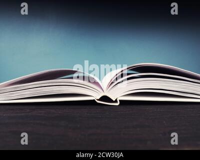 Open book on blue background, open pages as a concept of new knowledge, online self-study Stock Photo