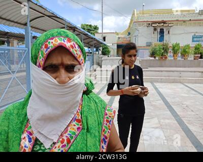 DISTRICT KATNI, INDIA - JULY 08, 2020: Indian traditional female wearing facemask for coronavirus protection at hindu religious place while travel. Stock Photo