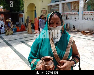 DISTRICT KATNI, INDIA - JULY 08, 2020: Indian traditional lady wearing facemask for coronavirus protection at hindu religious place while travel. Stock Photo