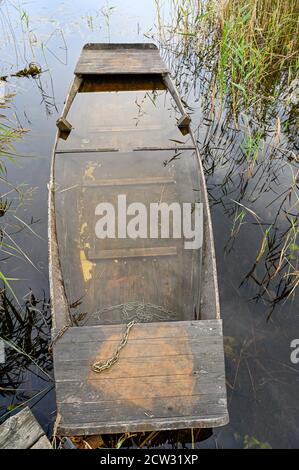 old wooden boat filled with water at jetty Stock Photo
