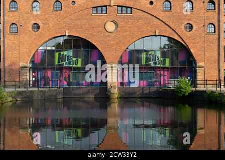 Hits Radio entrance, Castlefield, Manchester, UK with reflection in canal. Stock Photo