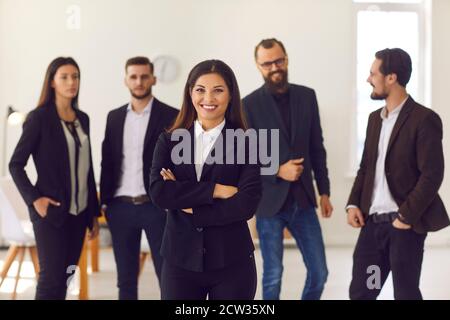Happy young female team leader or executive manager smiling and looking at camera Stock Photo