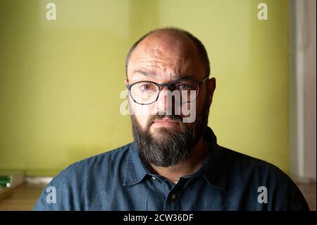 Man looks seriously insecure and doubtful into the camera Stock Photo