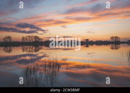 Reflection of colourful clouds in the lake Stock Photo