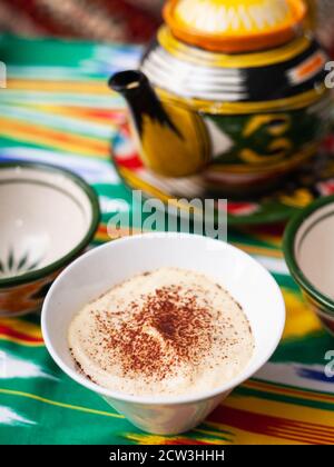 Tiramisu dessert in oriental style with a teapot and a cup for tea. Stock Photo