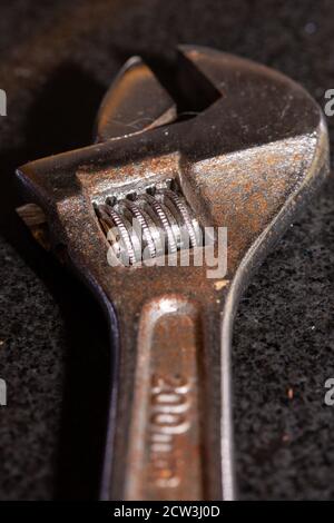 a close up of an old rust adjustable wrench using selective focus Stock Photo