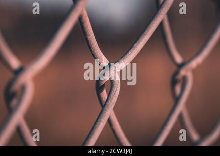 A close up of the links of a chain link fence using selective focus Stock Photo