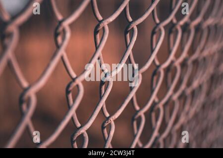 A close up of the links of a chain link fence using selective focus Stock Photo