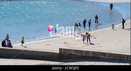 Lyme Regis, Dorset, UK. 27th September 2020. UK Weather: A bright and sunny day with a chilly wind at Lyme Regis.  People enjoy a bright and breezy day on the beach at Lyme Regis.  Credit: Celia McMahon/Alamy Live News. Stock Photo
