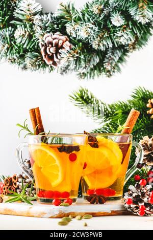 Winter hot tea with cranberry, lemon and spices in glass cup in Christmas or New Year's table setting, white background Stock Photo