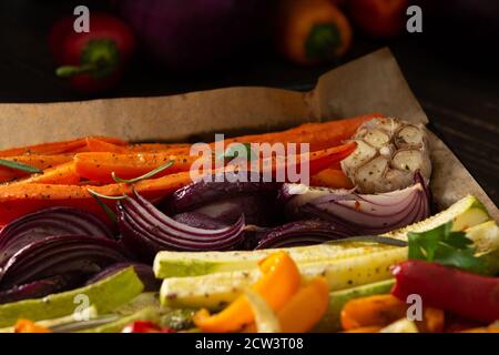 Stewed vegetables on a baking sheet, carrots with garlic and red onions,zucchini with bell pepper and beetroot, sweet and hot peppers and spices Stock Photo