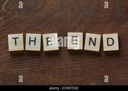 written 'THE END' with light wood letters on dark wood Stock Photo